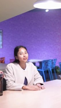 Tayvanlı 20 'li yaşlarda genç bir erkek ve kadın üniversite öğrencisi, Hintli bir kadınla birlikte Taipei City Dikey Bölgesi Da' an Üniversitesi 'nin kafeteryasında sohbet ediyorlar.