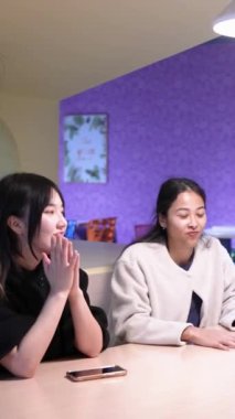 Tayvanlı 20 'li yaşlarda genç bir erkek ve kadın üniversite öğrencisi, Hintli bir kadınla birlikte Taipei City Dikey Bölgesi Da' an Üniversitesi 'nin kafeteryasında sohbet ediyorlar.