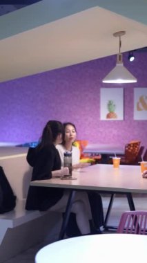 Tayvanlı 20 'li yaşlarda genç bir erkek ve kadın üniversite öğrencisi, Hintli bir kadınla birlikte Taipei City Dikey Bölgesi Da' an Üniversitesi 'nin kafeteryasında sohbet ediyorlar.