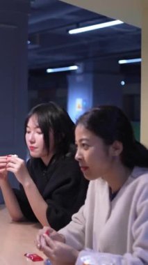 Tayvanlı 20 'li yaşlarda genç bir erkek ve kadın üniversite öğrencisi, Hintli bir kadınla birlikte Taipei City Dikey Bölgesi Da' an Üniversitesi 'nin kafeteryasında sohbet ediyorlar.