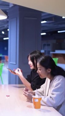 Tayvanlı 20 'li yaşlarda genç bir erkek ve kadın üniversite öğrencisi, Hintli bir kadınla birlikte Taipei City Dikey Bölgesi Da' an Üniversitesi 'nin kafeteryasında sohbet ediyorlar.