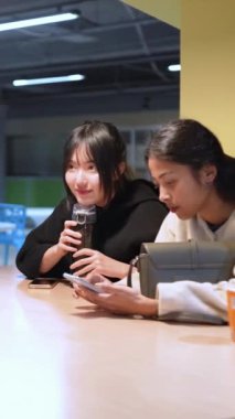 Tayvanlı 20 'li yaşlarda genç bir erkek ve kadın üniversite öğrencisi, Hintli bir kadınla birlikte Taipei City Dikey Bölgesi Da' an Üniversitesi 'nin kafeteryasında sohbet ediyorlar.