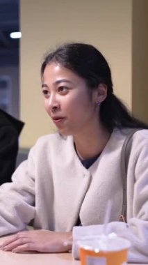 Tayvanlı 20 'li yaşlarda genç bir erkek ve kadın üniversite öğrencisi, Hintli bir kadınla birlikte Taipei City Dikey Bölgesi Da' an Üniversitesi 'nin kafeteryasında sohbet ediyorlar.