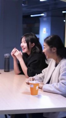 Tayvanlı 20 'li yaşlarda genç bir erkek ve kadın üniversite öğrencisi, Hintli bir kadınla birlikte Taipei City Dikey Bölgesi Da' an Üniversitesi 'nin kafeteryasında sohbet ediyorlar.