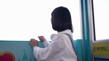 20 'li yaşlarında Tayvanlı genç bir kadın Tayvan' ın Taipei şehrindeki Shilin semtinde bir lunaparkta fotoğraf çekiyor ve müzik dinliyor. Yavaş çekim videosu.