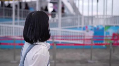 Tayvan 'ın Taipei şehrindeki Shilin Bölgesi' nde bir lunaparkta 20 'li yaşlarda genç bir Tayvanlı kadın akşam vakti yürüyor. Yavaş çekim videosu.