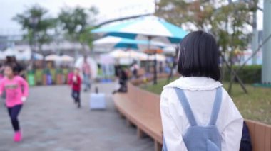 Tayvan 'ın Taipei şehrindeki Shilin Bölgesi' nde bir lunaparkta 20 'li yaşlarda genç bir Tayvanlı kadın akşam vakti yürüyor. Yavaş çekim videosu.