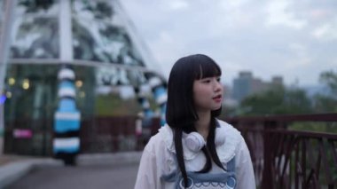 Tayvan 'ın Taipei şehrindeki Shilin Bölgesi' nde bir lunaparkta 20 'li yaşlarda genç bir Tayvanlı kadın akşam vakti yürüyor. Yavaş çekim videosu.