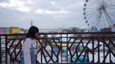 Tayvan 'ın Taipei şehrindeki Shilin Bölgesi' nde bir lunaparkta 20 'li yaşlarda genç bir Tayvanlı kadın akşam vakti yürüyor. Yavaş çekim videosu.