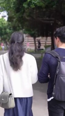 Tayvanlı 20 'li yaşlarda erkek ve bayan öğrenciler ve Tayvan' da Da 'an Bölgesi' nde bir üniversite kampüsünde sohbet eden Hintli bir kadın. Dikey.