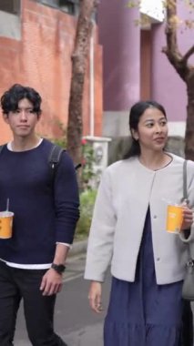 Tayvanlı 20 'li yaşlarda erkek ve bayan öğrenciler ve Tayvan' da Da 'an Bölgesi' nde bir üniversite kampüsünde sohbet eden Hintli bir kadın. Dikey.