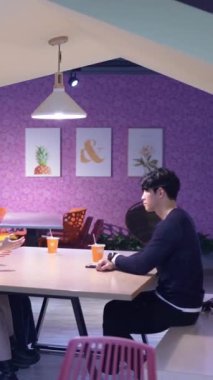 Tayvanlı 20 'li yaşlarda erkek ve bayan öğrenciler ve Hintli bir kadın Taipei City' deki Da 'an Bölgesi' nde üniversite kafeteryasında sohbet ediyorlar. Dikey yavaş hareket.