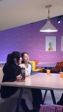 Tayvanlı 20 'li yaşlarda erkek ve bayan öğrenciler ve Hintli bir kadın Taipei City' deki Da 'an Bölgesi' nde üniversite kafeteryasında sohbet ediyorlar. Dikey yavaş hareket.