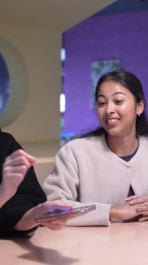 Tayvanlı 20 'li yaşlarda erkek ve bayan öğrenciler ve Hintli bir kadın Taipei City' deki Da 'an Bölgesi' nde üniversite kafeteryasında sohbet ediyorlar. Dikey yavaş hareket.