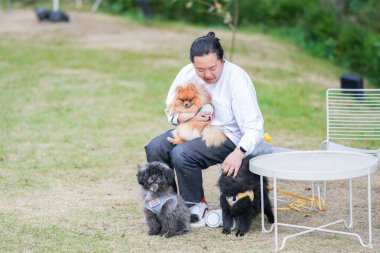 Adam şık bir kafede üç köpekle brunch yapıyor..