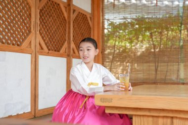 9 yaşındaki Koreli kız, Kore 'nin Seul bölgesindeki tarihi Gyedong-gil kasabasında geleneksel bir binada içki içiyor..