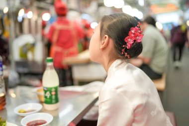 9 yaşındaki Koreli kız Changgyeonggung-ro, Jongno Bölgesi, Seul, Kore 'de yerel bir markette yemek yiyor..