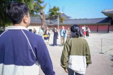Koreli bir çift, 30 'lu yaşlarda bir adam ve 20' li yaşlarda bir kadın, Güney Kore 'nin Seul şehrindeki tarihi bir binada uyumlu bir şekilde yürüyorlar..