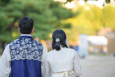 Koreli bir çift, 30 'lu yaşlarda bir adam ve 20' li yaşlarda bir kadın, Güney Kore, Seul 'de Hanbok giyerek halka açık bir yolda uyumlu bir şekilde yürüyorlar..