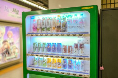 Su, soda ve meyve suyu dahil çeşitli içeceklerle otomat. Makine yeşil ve üzerinde kilit var.
