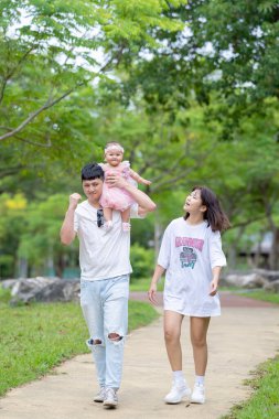 Tayvanlı bir çift 20 'li yaşlarda ve 7 aylık bebekleri Yilan County, Tayvan' da geniş bir yeşil parkta doğum gününü kutluyor..