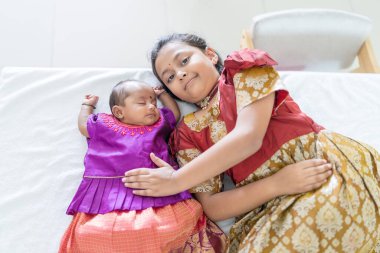 Geleneksel ve sıradan kostümler giyen Hintli bir aile, Malezya 'nın Kuala Lumpur kentindeki yüksek katlı bir apartmanda bebekleri, kızları ve büyükbabalarıyla vakit geçiriyor. Haziran 2024