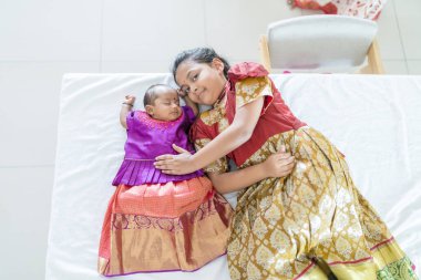 Geleneksel ve sıradan kostümler giyen Hintli bir aile, Malezya 'nın Kuala Lumpur kentindeki yüksek katlı bir apartmanda bebekleri, kızları ve büyükbabalarıyla vakit geçiriyor. Haziran 2024