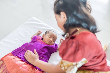 Geleneksel ve sıradan kostümler giyen Hintli bir aile, Malezya 'nın Kuala Lumpur kentindeki yüksek katlı bir apartmanda bebekleri, kızları ve büyükbabalarıyla vakit geçiriyor. Haziran 2024