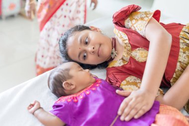 Geleneksel ve sıradan kostümler giyen Hintli bir aile, Malezya 'nın Kuala Lumpur kentindeki yüksek katlı bir apartmanda bebekleri, kızları ve büyükbabalarıyla vakit geçiriyor. Haziran 2024