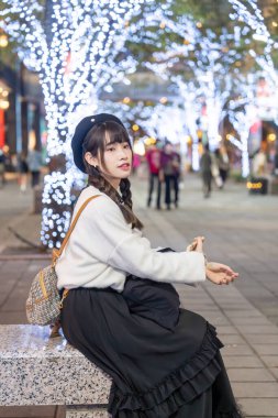 Tayvan 'ın Taipei bölgesindeki Xinyi semtinde bir alışveriş merkezinde gece vakti oturup dinlenen 20' li yaşlarda genç ve tatlı Tayvanlı bir kadın.