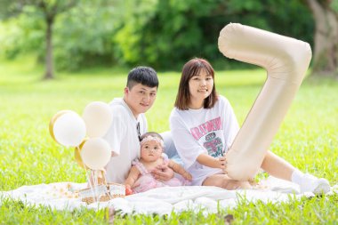 Tayvanlı bir çift 20 'li yaşlarda ve 7 aylık bebekleri Yilan County, Tayvan' da geniş bir yeşil parkta doğum gününü kutluyor..