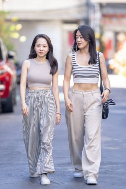 Eylül 'de Tayvan' ın Taipei şehrinde Dihua Caddesi 'nde 30' lu yaşlarda sıradan kıyafetler giyen iki Tayvanlı kadın yürüyor..