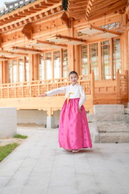 9 yaşındaki Koreli kız, Kore 'nin Seul bölgesindeki tarihi Gyedong-gil kasabasında geleneksel bir bina önünde geleneksel bir dans gösterisi yapıyor..