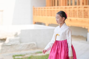 9 yaşındaki Koreli kız, Kore 'nin Seul bölgesindeki tarihi Gyedong-gil kasabasında geleneksel bir bina önünde geleneksel bir dans gösterisi yapıyor..