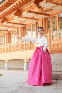 9 yaşındaki Koreli kız, Kore 'nin Seul bölgesindeki tarihi Gyedong-gil kasabasında geleneksel bir bina önünde geleneksel bir dans gösterisi yapıyor..