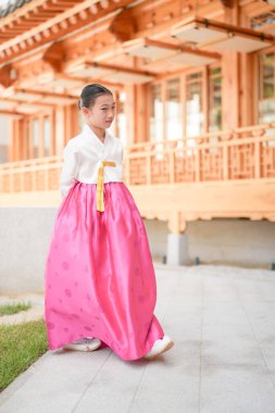 9 yaşındaki Koreli kız, Kore 'nin Seul bölgesindeki tarihi Gyedong-gil kasabasında geleneksel bir bina önünde geleneksel bir dans gösterisi yapıyor..