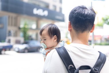 Tayvanlı bir kız, Eylül 'de Tayvan' ın Tayvan şehrinin sokaklarında güneşli bir günde, 20 'li yaşlarda bir adam olan babasıyla dışarı çıkıyor..