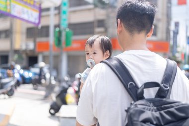 Tayvanlı bir kız, Eylül 'de Tayvan' ın Tayvan şehrinin sokaklarında güneşli bir günde, 20 'li yaşlarda bir adam olan babasıyla dışarı çıkıyor..