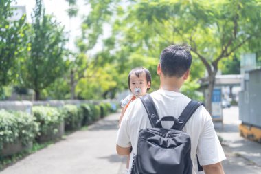 Tayvanlı bir kız, Eylül 'de Tayvan' ın Tayvan şehrinin sokaklarında güneşli bir günde, 20 'li yaşlarda bir adam olan babasıyla dışarı çıkıyor..