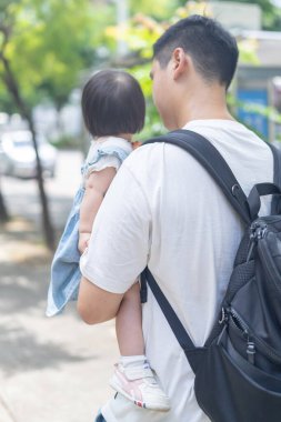 Tayvanlı bir kız, Eylül 'de Tayvan' ın Tayvan şehrinin sokaklarında güneşli bir günde, 20 'li yaşlarda bir adam olan babasıyla dışarı çıkıyor..