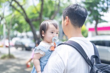 Tayvanlı bir kız, Eylül 'de Tayvan' ın Tayvan şehrinin sokaklarında güneşli bir günde, 20 'li yaşlarda bir adam olan babasıyla dışarı çıkıyor..