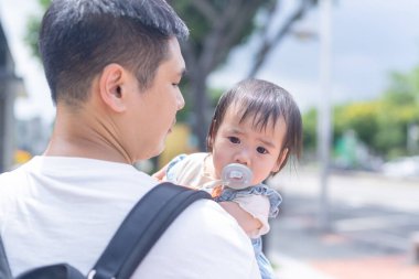 Tayvanlı bir kız, Eylül 'de Tayvan' ın Tayvan şehrinin sokaklarında güneşli bir günde, 20 'li yaşlarda bir adam olan babasıyla dışarı çıkıyor..