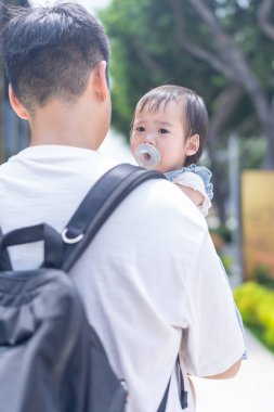 Tayvanlı bir kız, Eylül 'de Tayvan' ın Tayvan şehrinin sokaklarında güneşli bir günde, 20 'li yaşlarda bir adam olan babasıyla dışarı çıkıyor..