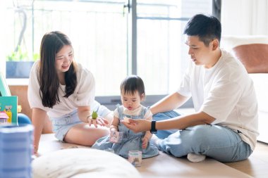 Tayvanlı bir kız, Tayvan 'ın başkenti Tayvan' da yüksek bir apartman dairesinde 20 'li yaşlarında bir erkek ve kadın olan ailesiyle mutlu bir şekilde vakit geçiriyor..