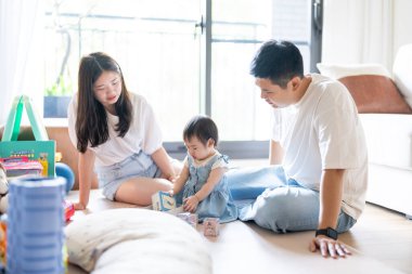 Tayvanlı bir kız, Tayvan 'ın başkenti Tayvan' da yüksek bir apartman dairesinde 20 'li yaşlarında bir erkek ve kadın olan ailesiyle mutlu bir şekilde vakit geçiriyor..