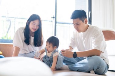 Tayvanlı bir kız, Tayvan 'ın başkenti Tayvan' da yüksek bir apartman dairesinde 20 'li yaşlarında bir erkek ve kadın olan ailesiyle mutlu bir şekilde vakit geçiriyor..