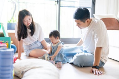 Tayvanlı bir kız, Tayvan 'ın başkenti Tayvan' da yüksek bir apartman dairesinde 20 'li yaşlarında bir erkek ve kadın olan ailesiyle mutlu bir şekilde vakit geçiriyor..