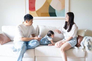 Tayvanlı bir kız, Tayvan 'ın başkenti Tayvan' da yüksek bir apartman dairesinde 20 'li yaşlarında bir erkek ve kadın olan ailesiyle mutlu bir şekilde vakit geçiriyor..