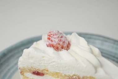 Küçük bir Japon çilekli pastası. Beyaz bir masada, şık bir Japon tabağı üzerinde..