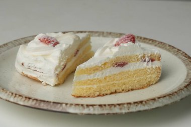 İki Japon çilekli pastası beyaz bir masada büyük bir tabakta..